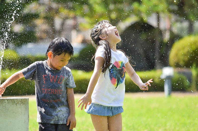 笑顔で水遊びをする子供たち